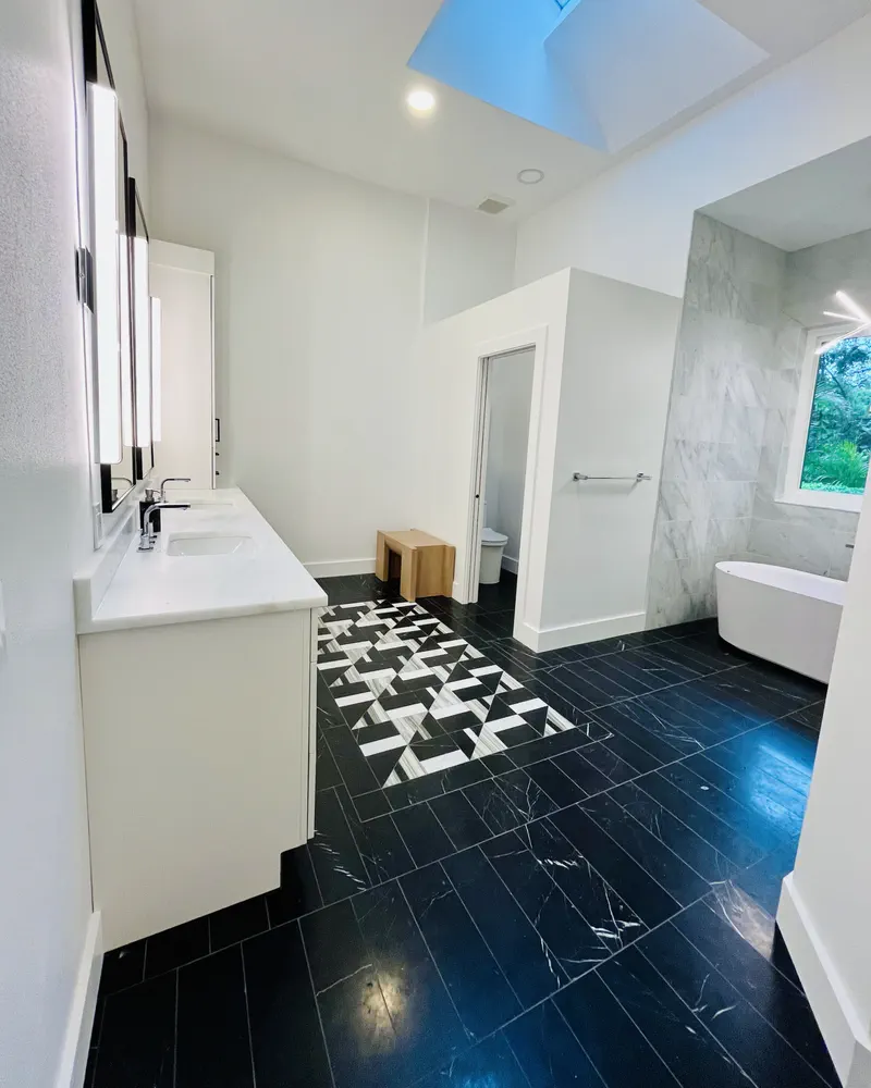 Black marble bathroom floor with a centered geometric inlay